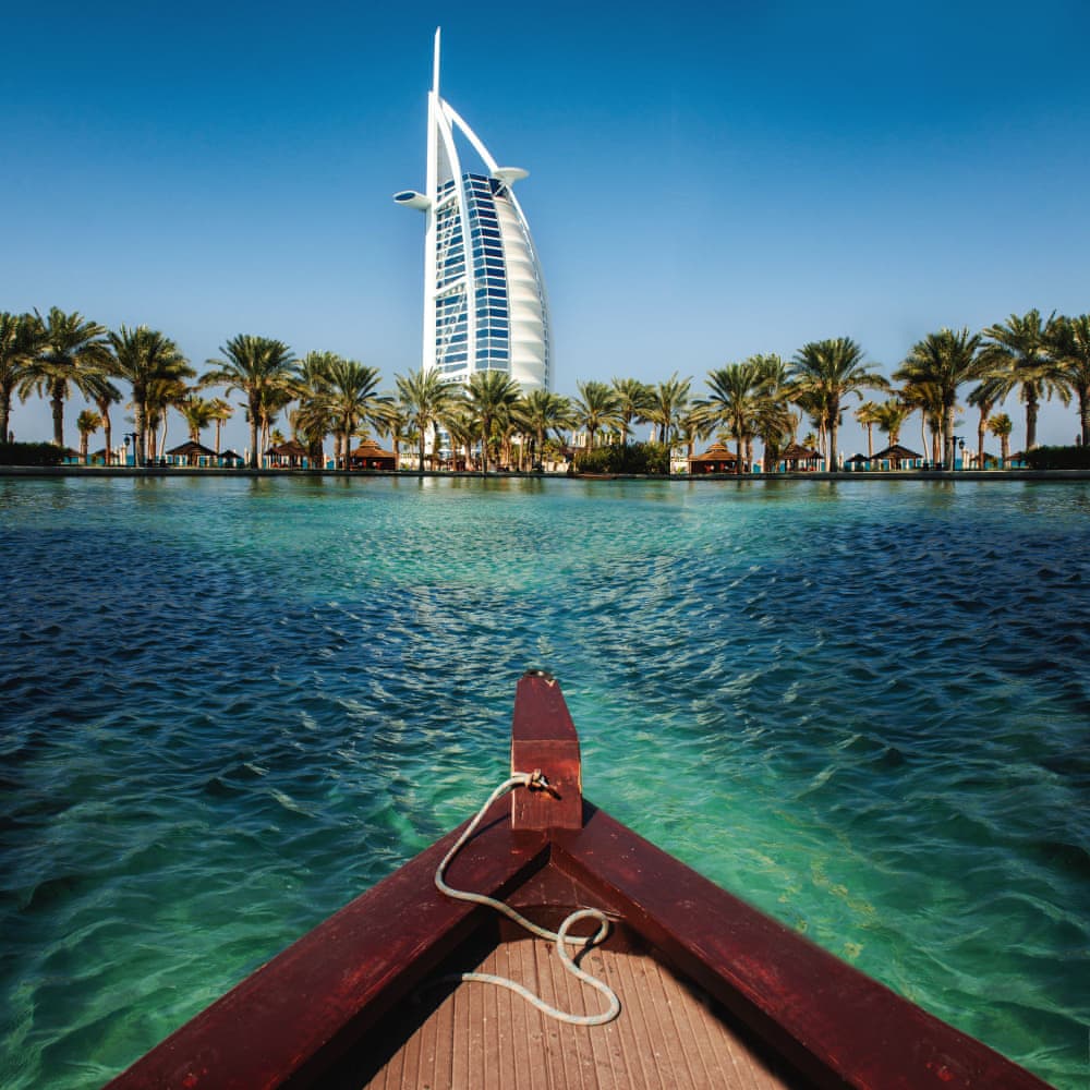 Dubai Burj Al Arab oteli ve palmiye ağaçlarıyla çevrili manzarası.