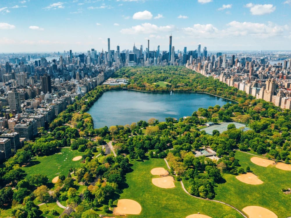 Aerial view of Central Park with golf courses and tall skyscrapers surrounding the park.